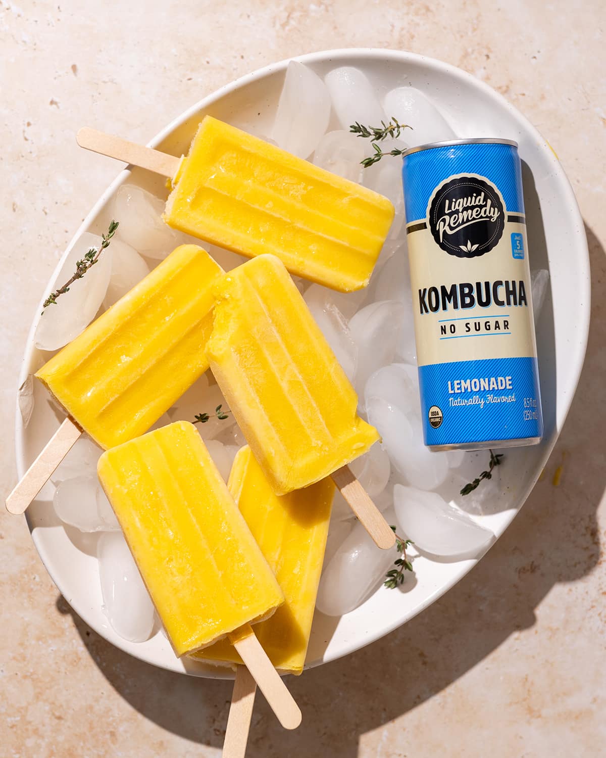 Lemonade Kombucha Popsicles next to a Liquid Remedy Kombucha can